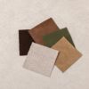 Five chair fabric swatches: oatmeal linen, green velvet, chocolate velvet, light vegan leather and tan vegan leather
