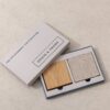 Grain and Frame sample pack box, open, showing a solid oak coaster and an oatmeal linen fabric swatch